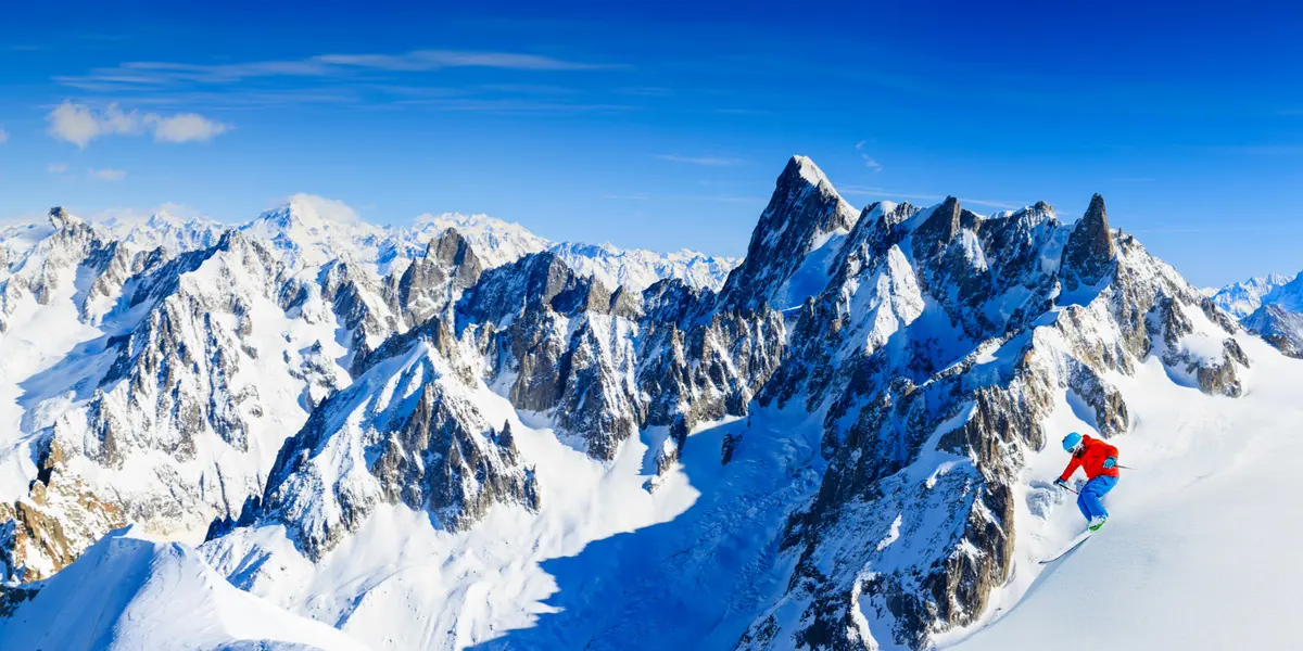A skier in front of the jagged peaks of the Mont Blanc massif